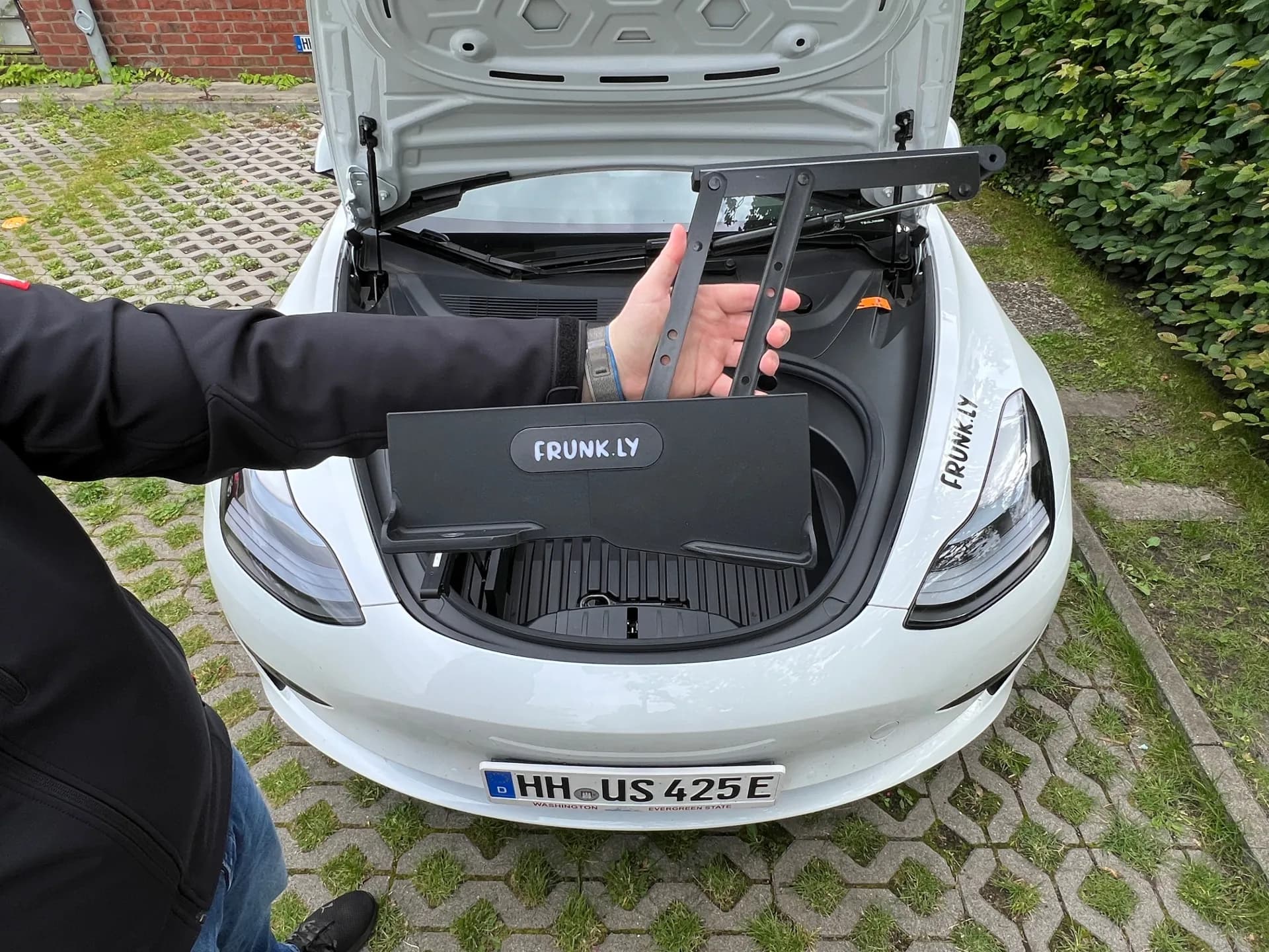 Frunkly LT being unfolded from a Tesla Model 3 frunk, showing the compact folding mechanism
