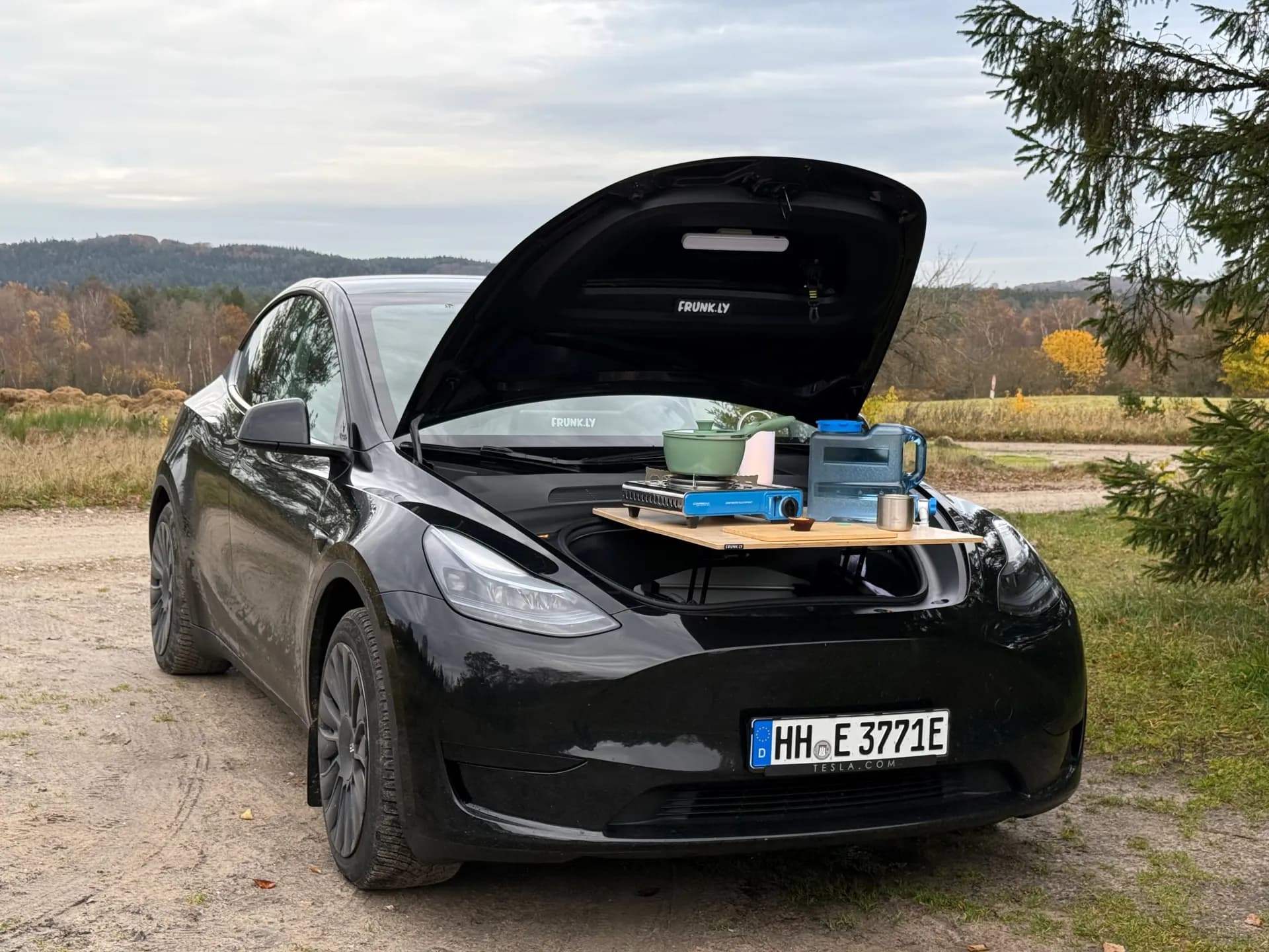 Tesla Model Y with Frunkly table set up as outdoor camping kitchen with stove and cookware